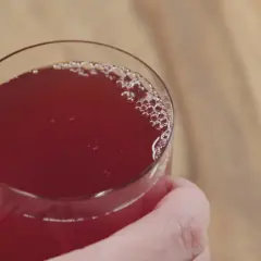 Szklanka z czerwonym napojem, który może być odpowiedzią na pytanie co pić na chore nerki.