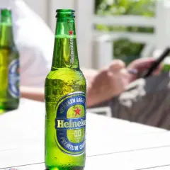 Chłodne piwo Heineken 0.0 na stole. Zastanawiasz się, ile węglowodanów ma piwo? To piwo jest bezalkoholowe.