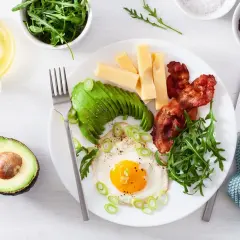 Śniadanie keto: jajko sadzone, awokado, boczek, ser i rukola. Idealne, gdy zastanawiasz się, dieta low carb co to.