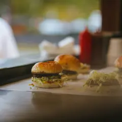 Trzy soczyste burgery, prawdziwe bomby kaloryczne na przytycie, gotowe do podania.