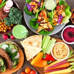 Kolorowe, wegańskie potrawy: sałatki, wrapy, hummus, smoothie i pieczywo. To pokazuje, co to jest weganizm – dieta roślinna pełna smaków i zdrowia.