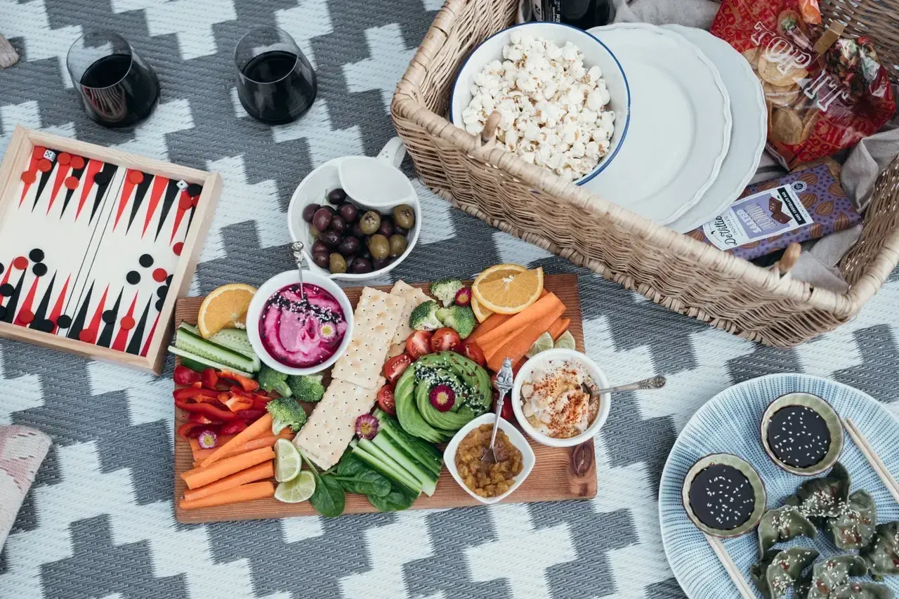 Piknikowy stół z warzywami, dipami i popcornem. Idealna opcja dla weganizmu a wegetarianizmu.