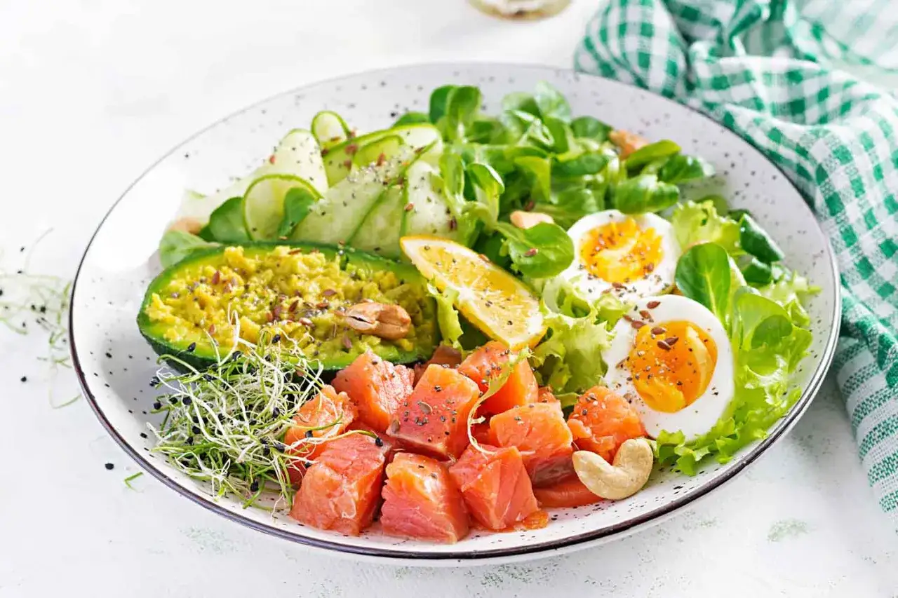 Kolorowa sałatka z łososiem, awokado, jajkiem i warzywami. Idealna odpowiedź na pytanie: low carb co to?