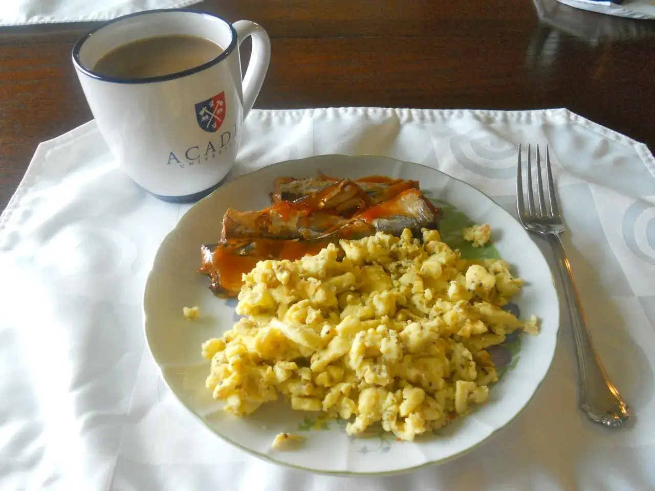 Jajecznica i ryba w sosie na talerzu, kawa w kubku. Idealny posiłek na dieta dukana faza 1 jadłospis na tydzień.